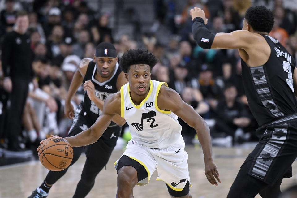 Utah Jazz's Collin Sexton (2) drives against San Antonio Spurs' Keldon Johnson (3) during the first half of an NBA basketball game Tuesday, Dec. 26, 2023, in San Antonio. (AP Photo/Darren Abate)