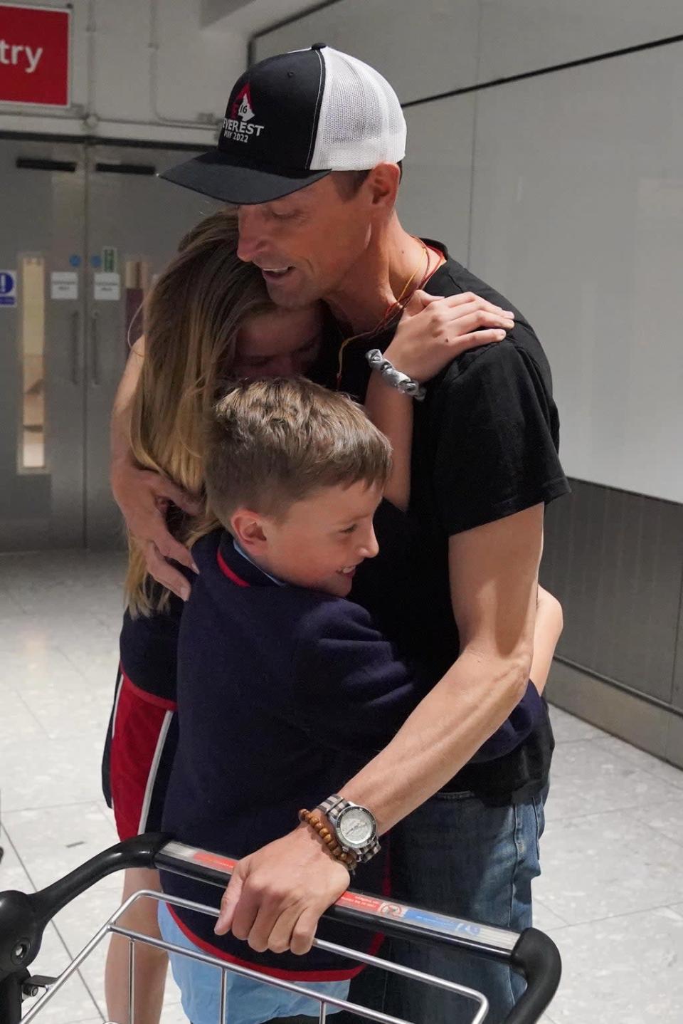 Kenton Cool was embraced by daughter Saffron and son Willoughby at Heathrow Airport (Jonathan Brady/PA) (PA Wire)