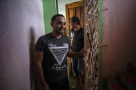 Partners Adiel González, front, and Lázaro “Lachi” González, leave their home in Matanzas, Cuba, Thursday, Oct. 7, 2021. The socialist government recently published a draft Family Law and asked for public comment ahead of a referendum on legalizing same-sex marriage, as well as expanding grandparents rights, allowing for prenuptial agreements and in cases of divorce, create financial consequences for those who have committed gender violence, amid a total of 480 articles. (AP Photo/Ramon Espinosa)