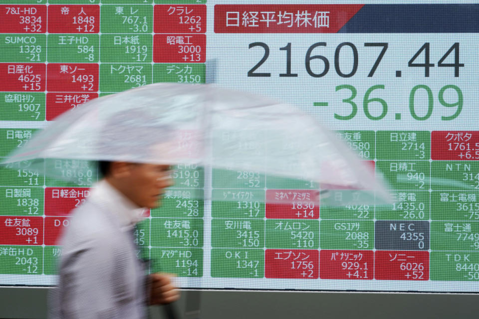 A man walks past an electronic stock board showing Japan's Nikkei 225 index at a securities firm in Tokyo Friday, July 12, 2019. Shares in Asia are mostly higher after a turbulent day on Wall Street ended with the Dow Jones Industrial Average closing above 27,000 for the first time. (AP Photo/Eugene Hoshiko)