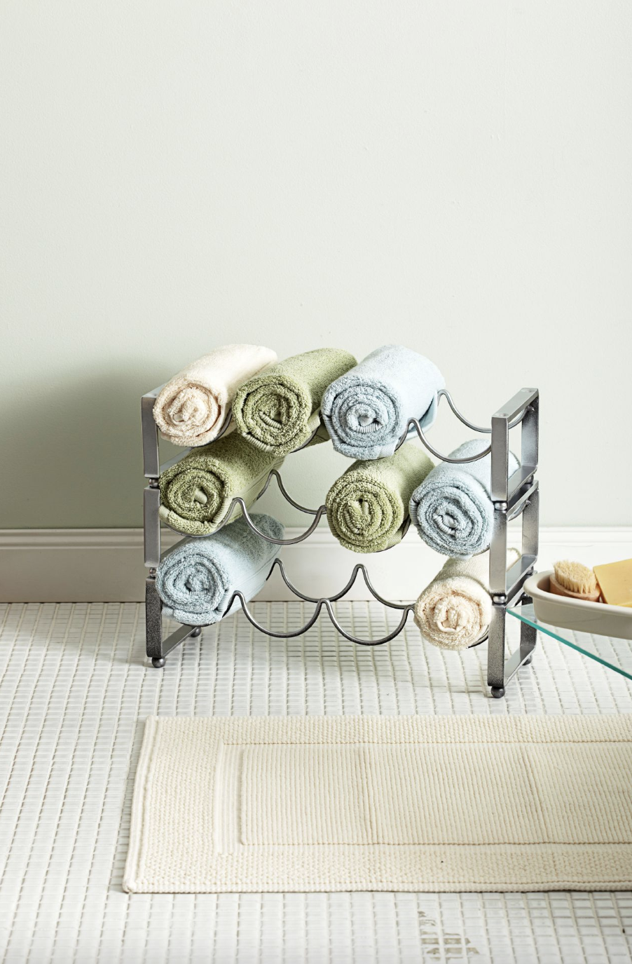 bathroom storage ideas, rolled towels on a rack on the floor