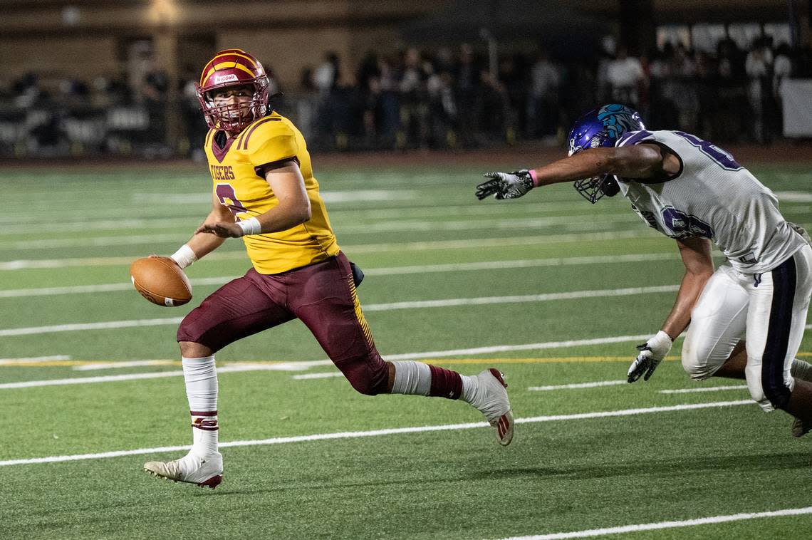 Los Banos quarterback David Herrera rolls out as Johansen’s Anthony Alves gives chase during the Western Athletic Conference game at Johansen High School in Modesto, Calif., Friday, Oct. 6, 2023.