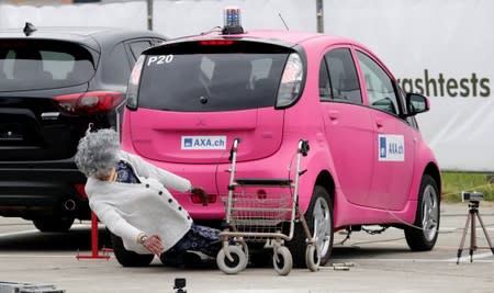 A Mitsubishi i-MiEV electric car collides with a crash test dummy with a rollator in a controlled crash test from insurer AXA in Duebendorf