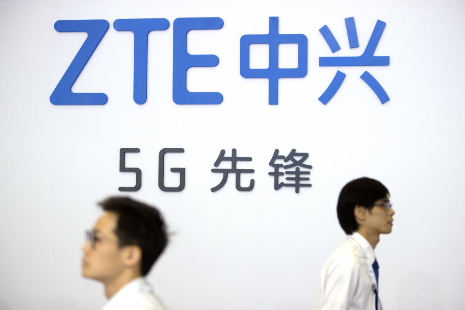 FILE - In this Sept. 26, 2018, file photo, visitors walk beneath the logo of Chinese technology firm ZTE at the PT Expo in Beijing. The Federal Communications Commission on Friday, Nov. 22, 2019 voted, 5-0, to bar U.S. telecommunications providers from using government subsidies to pay for networking equipment from companies that are a threat to national security. The agency says China’s Huawei and ZTE pose such a threat. (AP Photo/Mark Schiefelbein, File)