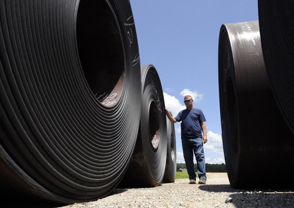 In this Tuesday, July 23, 2019 photo, Mark Alred stands amid huge rolls of steel at the Yellow Creek State Inland Port on the Tennessee-Tombigbee Waterway in Iuka, Miss. The waterway hasn't lived up to expectations in terms of barge traffic or economic development in parts of Alabama and Mississippi, but the port provides jobs and helps the economy in Iuka, located near the Tennessee line. (AP Photo/Jay Reeves)