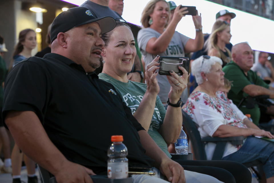 Lisa DeMarco and Rey Martinez watch students on the field during the opening of the new Children's Health Stadium at Prosper ISD on Saturday, Aug. 17, 2019 in Prosper, Texas. Democrats are out to show they’re serious about flipping Texas in 2020 by holding Thursday’s presidential debate in Houston. Republicans are coming off their worst election in Texas in a generation. Fast-changing suburbs are trending more liberal, and Democrats are counting on more left-leaning voters moving in to turn the state blue. But that transformation may not arrive by 2020, and the GOP is closely watching conservative bastions like the booming Dallas suburbs. (AP Photo/Nathan Hunsinger)