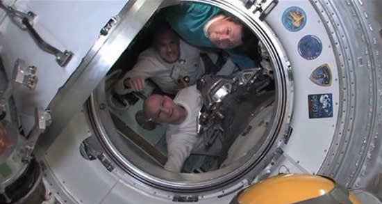 Expedition 31 commander Oleg Kononenko of Russia (top), Dutch astronaut Andrew Kuipers (center) and NASA astronaut Don Pettit bid farewell to their crewmates on the International Space Station just before shutting the hatches between their Soyu