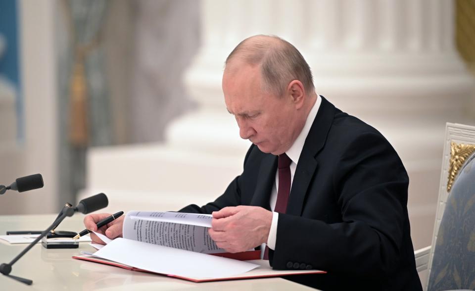 Russian President Vladimir Putin signs a document recognizing the independence of separatist regions in eastern Ukraine in the Kremlin in Moscow, Russia, Monday, Feb. 21, 2022. Russia's Putin has recognized the independence of separatist regions in eastern Ukraine, raising tensions with West. (Alexei Nikolsky, Sputnik, Kremlin Pool Photo via AP)