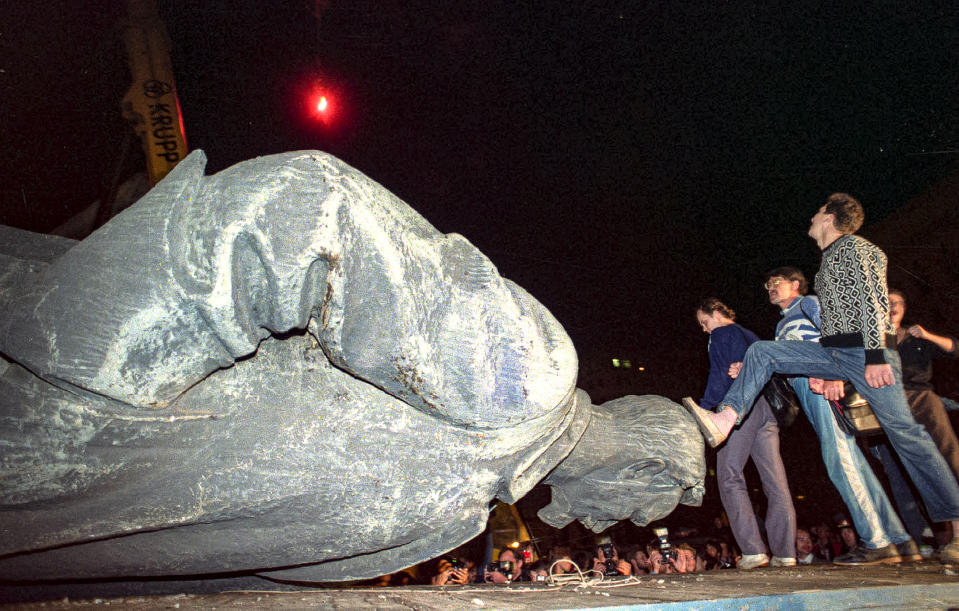 FILE - In this Friday, Aug. 23, 1991 file photo, people kick the head of the statue of Felix Dzerzhinsky, the founder of the Soviet secret police, in front of the KGB main headquarters on the Lubyanka Square. When a group of top Communist officials ousted Soviet leader Mikhail Gorbachev 30 years ago and flooded Moscow with tanks, the world held its breath, fearing a rollback on liberal reforms and a return to the Cold War confrontation. But the August 1991 coup collapsed in just three days, precipitating the breakup of the Soviet Union that plotters said they were trying to prevent. (AP Photo/Alexander Zemlianichenko, File)