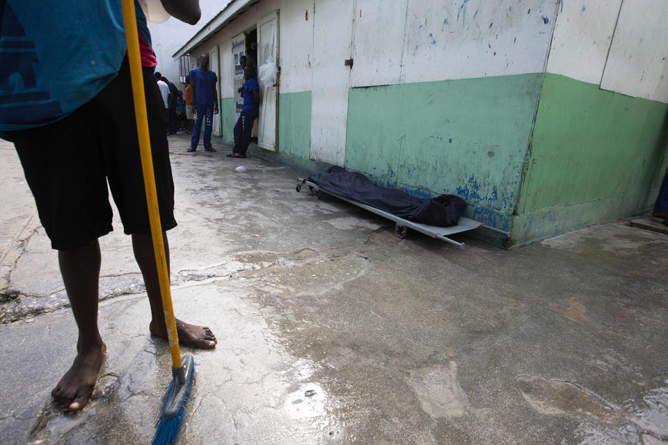 <p>A prisoner stands near the body of an inmate, covered with a plastic tarp, who died of malnutrition inside the National Penitentiary in downtown Port-au-Prince, Haiti, Feb. 13, 2017. Overcrowding, malnutrition and infectious diseases that flourish in jammed quarters has led to an upsurge of inmate deaths. (Photo: Dieu Nalio Chery/AP) </p>