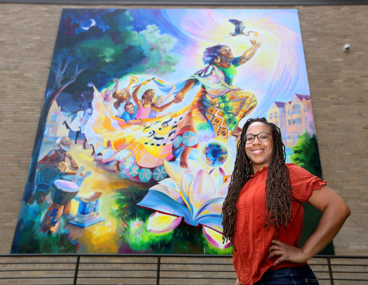 Milwaukee artist Tia Richardson stands in front of a community mural she created, "The Rebirthing of the Earth Mother," at 2215 N. Phillips Ave. A new Wisconsin Policy Forum report says work opportunities for Milwaukee County artists and creatives have not returned to pre-pandemic levels.