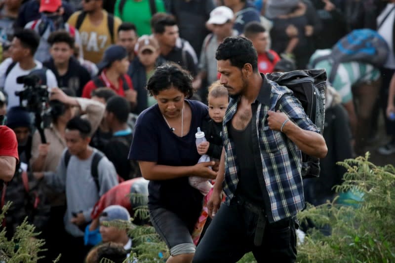 Migrants, mainly from Central America and marching in a caravan, walk after crossing the Suchiate river, on the outskirts of Ciudad Hidalgo