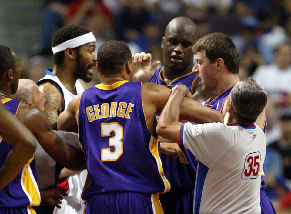Los Angeles Lakers guard Devean George (3) helps separate forward Slava Medvedenko, right, and Detroit Pistons forward Rasheed Wallace during a confrontation in the third quarter of game 4 their NBA Finals in Auburn Hills, Michigan, in a June13, 2004 file photo. / Credit: AP/PAUL SANCYA
