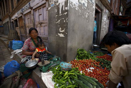 A woman from Sindhupalchok district holds her granddaughter as she sells vegetables along the streets of Bhaktapur after last week's earthquake 2 May 2015. According to the woman, her house was destroyed during the earthquake. REUTERS/Navesh Chitrakar