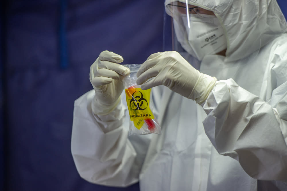 A health worker puts a test tube into biohazard plastic after collecting a sample for Covid-19 testing in Jalan Pudu, Kuala Lumpur, January 18, 2021. — Picture by Shafwan Zaidon