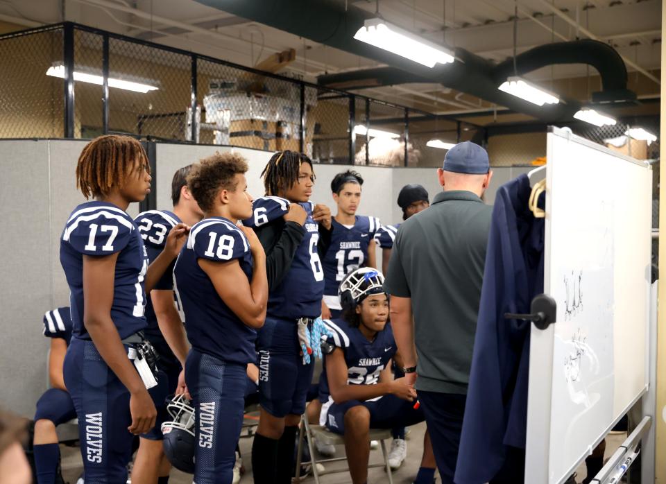 Shawnee football players review plays in a temporary locker room before a game against Carl Albert on Sept. 28 at Crain Family Stadium on the Oklahoma Baptist University campus in Shawnee.