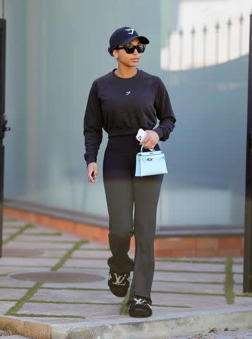 Alessandra Ambrosio looks stunning in an oversized grey sweater and lavender  leggings while leaving a gym