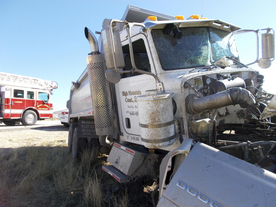 This Friday, Oct. 19, 2018 photo provided by the Utah Highway Patrol shows the scene of a head-on collision of a dump truck and a pickup on a state highway near Heber, Utah. State troopers say the dump truck crossed a highway median and collided with the pickup truck traveling in the opposite direction, killing all six men in the pickup in an accident authorities suspect may was caused by alcohol and prescription drugs. The Utah Highway Patrol said Saturday its officers found prescription pills and open containers of alcohol inside the dump truck. (Utah Highway Patrol via AP)