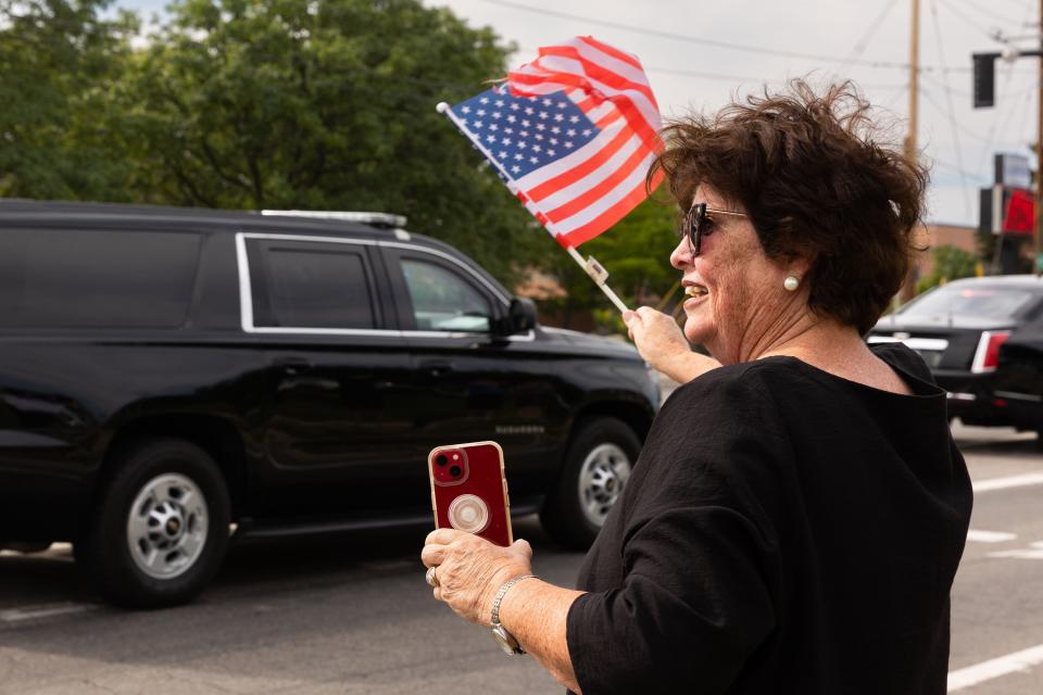 Kathy Stidham waves her American flag as the presidential motorcade drives out of the Roland R. Wright Air National Guard Base in Salt Lake City on Wednesday, Aug. 9, 2023. | Megan Nielsen, Deseret News