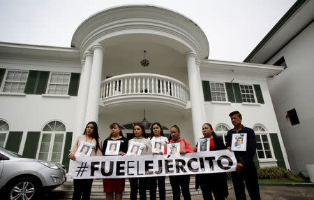 Relatives of people who went missing in 2009 pose for a picture in front of the Inter-American Court of Human Rights building after attending a hearing convened by the judges in San Jose, Costa Rica April 26, 2018. The banner that says "It was the army". REUTERS/Juan Carlos Ulate