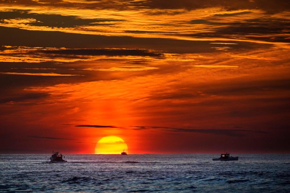 Lobster fishermen are already at work as the sun rises over the Atlantic Ocean, Thursday, Sept. 8, 2022, off of Kennebunkport, Maine.
