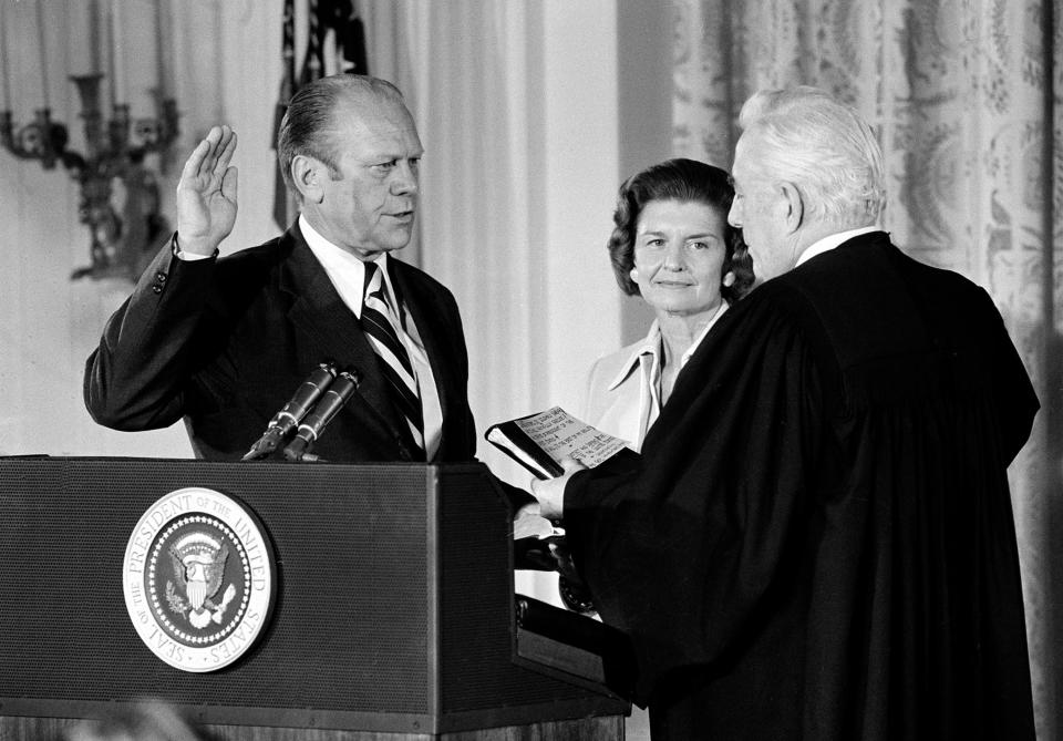 U.S. Chief Justice Warren Burger, right, administers the oath of office to Gerald R. Ford as the 38th President of the United States in the East Room of the White House in Washington, D.C., Aug. 9, 1974. Betty Ford holds the bible at center. Gerald R. Ford, who picked up the pieces of Richard Nixon's scandal-shattered White House as the 38th and only unelected president in America's history