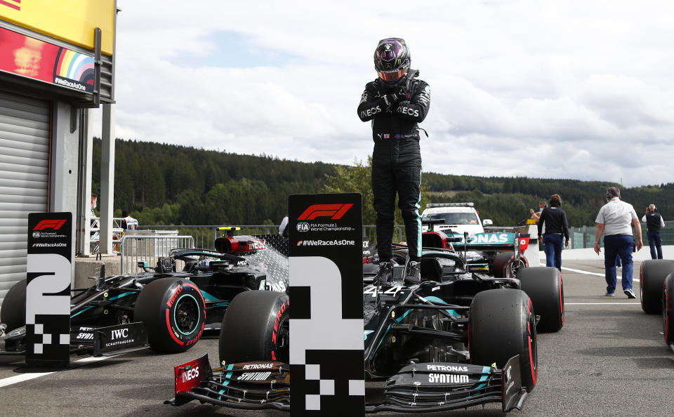 Mercedes driver Lewis Hamilton of Britain stands on his car after setting the fastest time during the qualifying session prior to the Formula One Grand Prix at the Spa-Francorchamps racetrack in Spa, Belgium Saturday, Aug. 29, 2020. Hamilton will start in pole position for race on Sunday. (Francois Lenoir, Pool via AP)