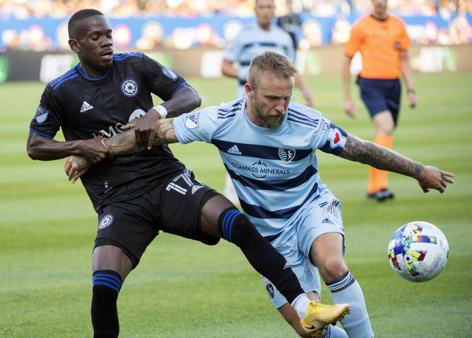 CF Montreal's Jojea Kwizera, left, challenges Sporting Kansas City's Johnny Russell during the first half of an MLS soccer match Saturday, July 9, 2022, in Montreal. (Graham Hughes/The Canadian Press via AP)