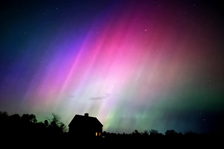 The northern lights flare in the sky over a farmhouse, late Friday, May 10, 2024, in Brunswick, Maine. Brilliant purple, green, yellow and pink hues of the Northern Lights were reported worldwide, with sightings in Germany, Switzerland, London, and the United States and Canada. (AP Photo/Robert F. Bukaty)