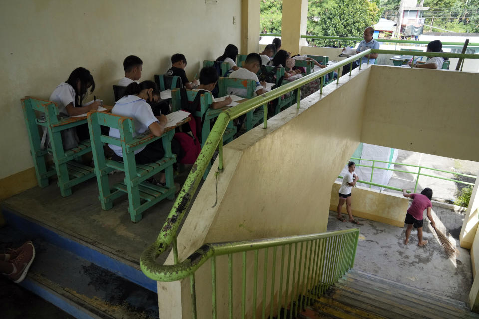 Students hold class along the hallways because the school was converted into a temporary evacuation center at Malilipot town, Albay province, northeastern Philippines, Thursday, June 15, 2023. Thousands of residents have left the mostly poor farming communities within a 6-kilometer (3.7-mile) radius of Mayon's crater in forced evacuations since volcanic activity spiked last week. (AP Photo/Aaron Favila)