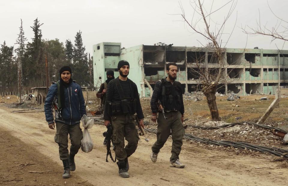 Free Syrian Army fighters walk with their weapons at the Tameko pharmaceutical factory, after the FSA claimed to have taken control of the factory, in eastern al-Ghouta, near Damascus January 14, 2014. REUTERS/Yaseen Abelall (SYRIA - Tags: POLITICS CIVIL UNREST CONFLICT)