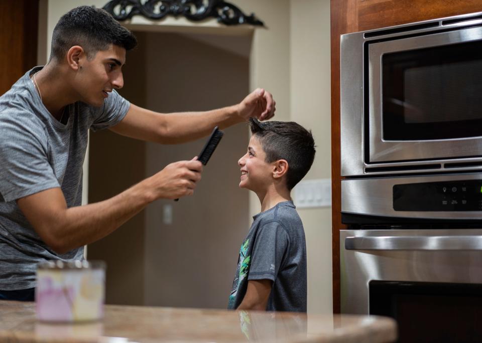 Saleh Humaid, 8, of Gaza, gets his hair styled by Mohamed Hamed, 21, of Dearborn Heights, at Hamed's home while getting Saleh ready for his going-away party on Tuesday, Aug. 8, 2023, before returning back to his home after receiving a prosthetic leg and rehabilitation in the United States while staying with Hamed's family.