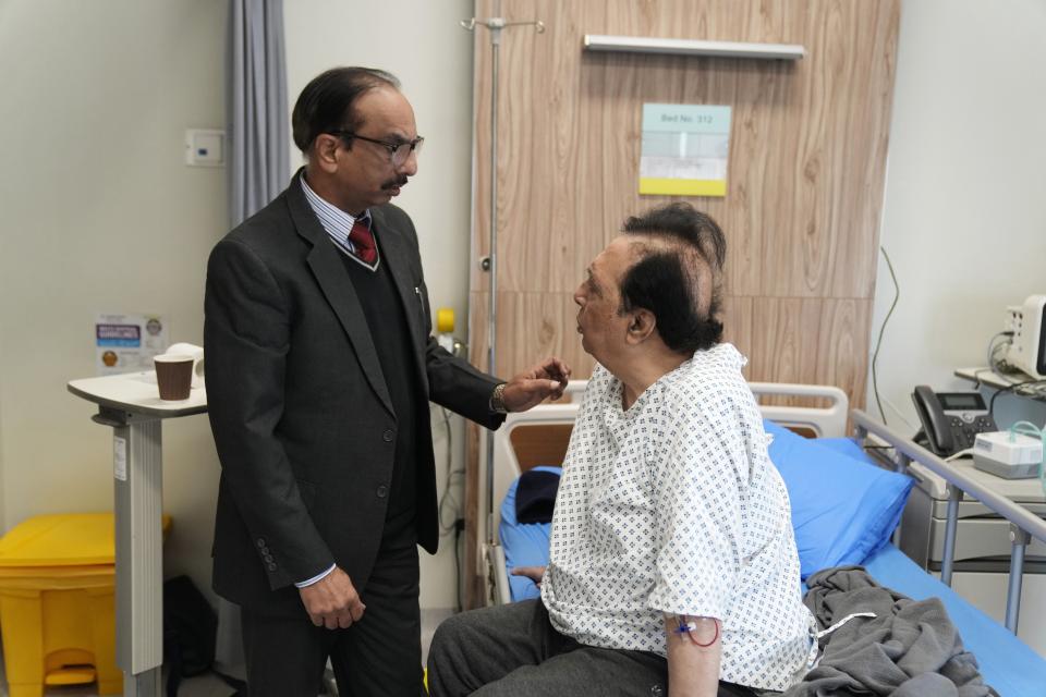 Pulmonologist Dr. Khawar Abbas Chaudhry talks to poet and former ambassador Ata Ul Haq Qasmi who is being treated for respiratory issues exacerbated by air pollution in Lahore, Pakistan, Thursday, Jan. 11, 2024. "If my friends aren't in hospital, they should be," he said. "You only have to step outside for it [the smog] to grab you." (AP Photo/K.M. Chaudary)