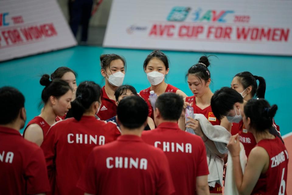Chinese players, some wearing face masks, gather during their preliminary match against Iran (AP)