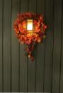 <p>Instead of placing a Thanksgiving wreath around a knocker or elsewhere on the front door, put them on a pair of sconces flanking it. </p>