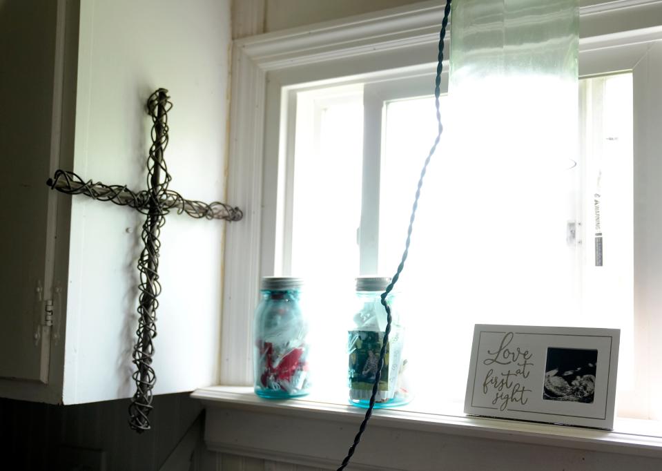 A cross hangs Tuesday in the kitchen of Justin and Nellie Hayes’ home in Newton Township. A photo from the couple’s first ultrasound sits on the window sill. Baby Elleanor was due three weeks from when Nellie died in March.