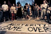 People shout slogans in front of the White Tower in Thessaloniki on July 5, 2015, celebrating a vote rejecting further austerity measures