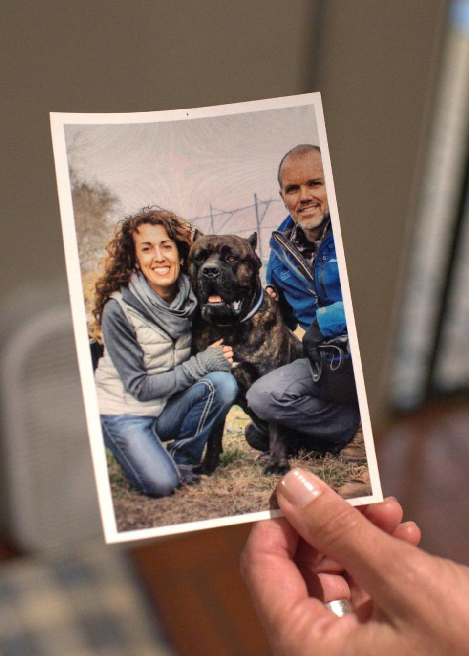 Emily McLeod holds a photograph picturing herself, her husband Dave Jennings and Oscar, an award-winning purebred Cane Corso they say is a missing member of their family. The couple have been locked in a yearslong legal dispute over Oscar’s ownership that was recently weighed by the Kansas Supreme Court.