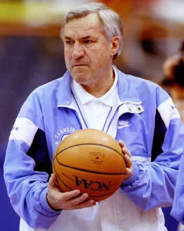 North Carolina head basketball coach Dean Smith carries the ball into the Tar Heel's practice as his team prepares for the NCAA Eastern Championship in Syracuse, New York, in this file photo taken March 20, 1997. REUTERS/Stringer