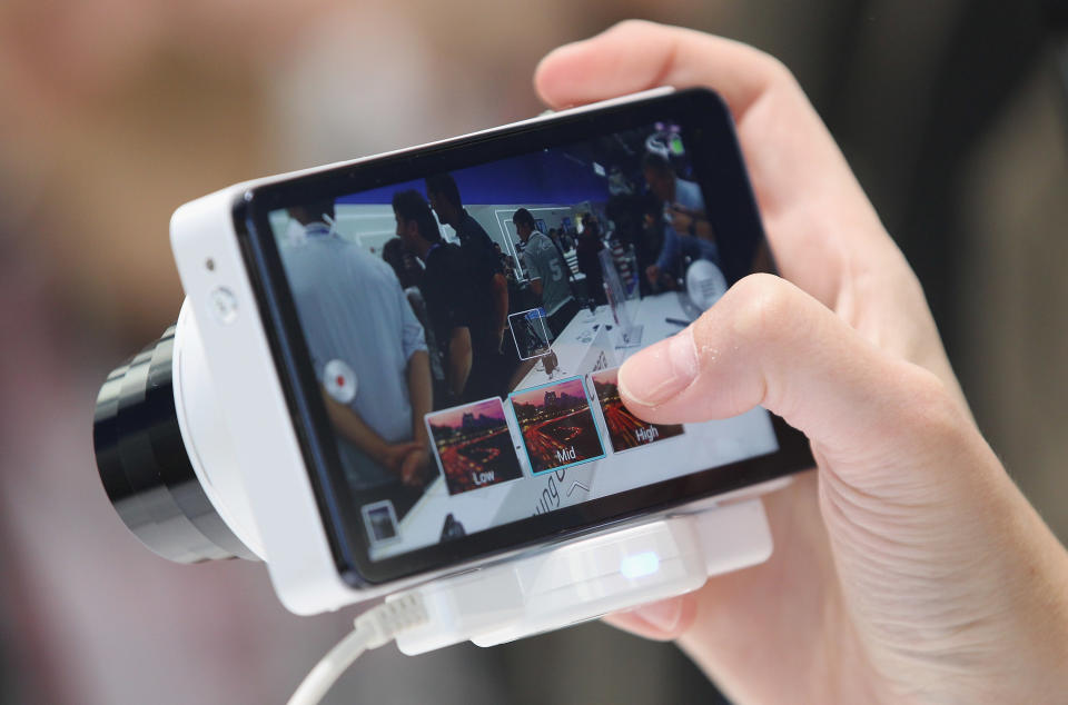 BERLIN, GERMANY - AUGUST 30: A visitor tries out the new Samsung Galaxy Camera, which combines a smartphone and a digital camera with a zoom lens, during a press day at the Samsung stand at the IFA 2012 consumer electronics trade fair on August 30, 2012 in Berlin, Germany. IFA 2012 will be open to the public from August 31 through September 5. (Photo by Sean Gallup/Getty Images)