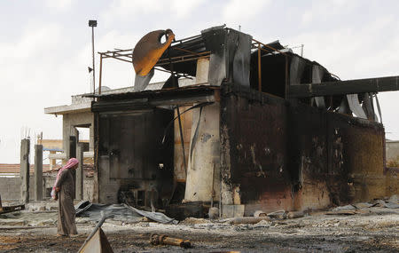 A man inspects damage at an oil refinery and a gas station that were targeted by what activists said were U.S.-led air strikes, in the town of Tel Abyad of Raqqa governorate, near the border with Turkey October 2, 2014. REUTERS/Stringer