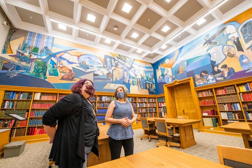 Rebecca Baumann, left, head of public services for Indiana University's Lilly Library, and Diane Dallis-Comentale, interim dean of IU libraries, discuss the new mural  Wednesday, August 25, 2021, at the renovated Lilly Library.