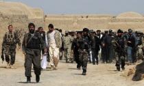 An Afghan delegation walks with locals after a gathering for a memorial ceremony at a mosque in Alokozai village in Panjwayi district, Kandahar province, on March 13, 2012. Gunmen on Tuesday attacked the memorial service for 16 villagers killed by a US soldier, shooting dead a member of the Afghan military and wounding a policeman in a hail of gunfire