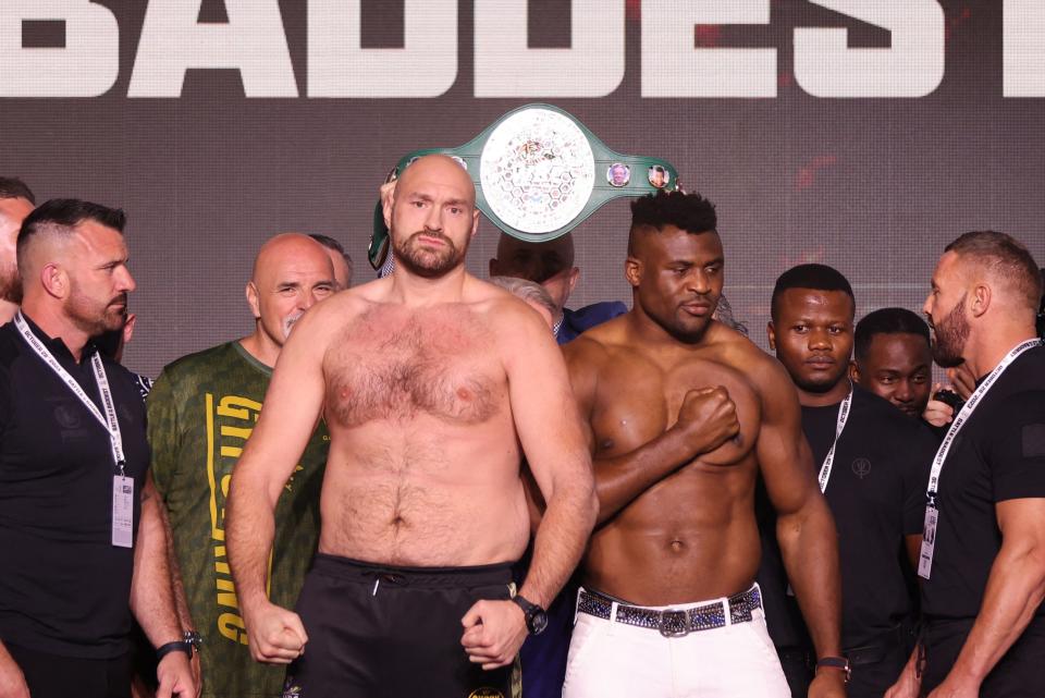 Tyson Fury, centre left, and Francis Ngannou at their weigh-in (REUTERS)