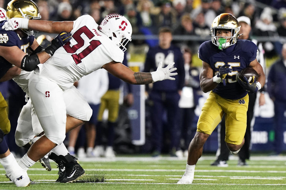 Notre Dame running back Chris Tyree, right, runs with the ball against Stanford defensive lineman Jaxson Moi during the first half of an NCAA college football game in South Bend, Ind., Saturday, Oct. 15, 2022. (AP Photo/Nam Y. Huh)
