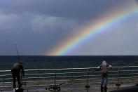 Fishermen prepare to fish as a rainbow appears over the Mediterranean Sea in Beirut, Lebanon, Sunday, Oct. 17, 2021. (AP Photo/Bilal Hussein)