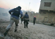 <p>Journalists, U.S. troops and Iraqi police run for cover during a firefight with insurgents January 16, 2005 in Tal Afar, Iraq. A routine patrol in the insurgent stronghold turned into an hour-long running gunbattle January 16, with a combined U.S. and Iraqi police force battling insurgents across alleys and down boulevards. Despite several close calls, there were no U.S. or Iraqi police casualties. (Photo by Chris Hondros/Getty Images) </p>
