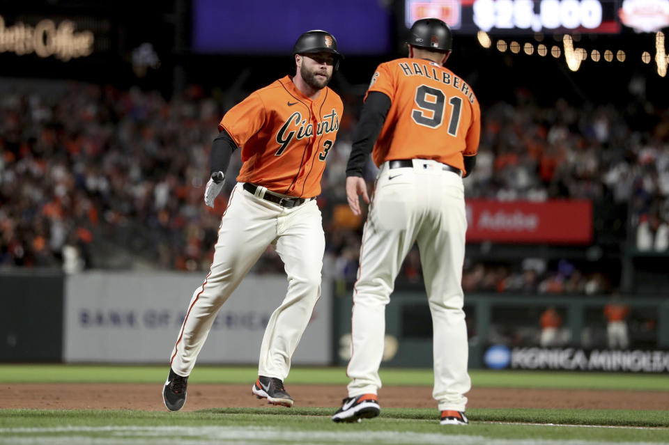 San Francisco Giants' Darin Ruf, left, is congratulated by third base coach Mark Hallberg (91) after hitting a home run against the Los Angeles Dodgers during the eighth inning of a baseball game in San Francisco, Friday, June 10, 2022. (AP Photo/Jed Jacobsohn)