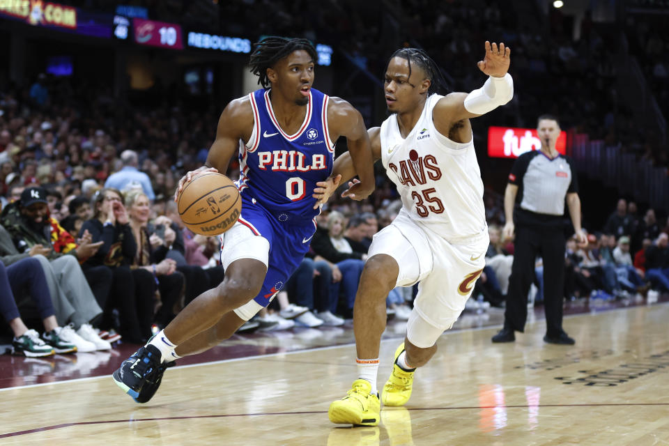 Philadelphia 76ers guard Tyrese Maxey (0) drives against Cleveland Cavaliers forward Isaac Okoro (35) during the first half of an NBA basketball game Friday, March 29, 2024, in Cleveland. (AP Photo/Ron Schwane)