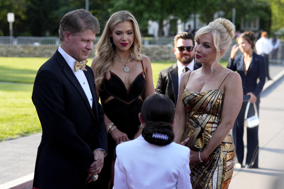 Kansas City Chiefs owner Clark Hunt with his wife Tavia and daughter Gracie talk to a young reporter on the red carpet before a ceremony for team members to receive their championship rings for winning NFL's Super Bowl 58 football game Thursday, June 13, 2024, in Kansas City, Mo. (AP Photo/Charlie Riedel)